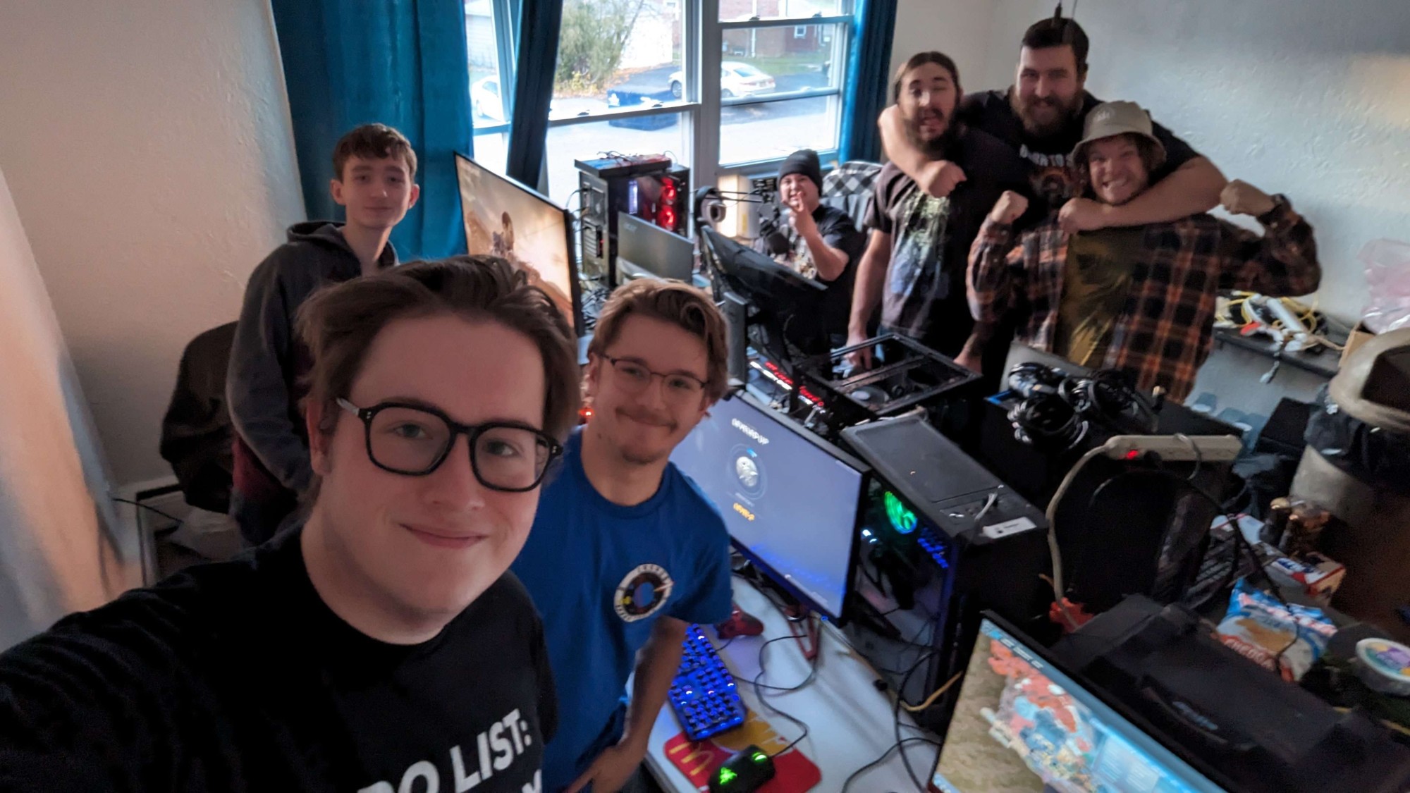 A group selfie of grinning guests around their gaming setups at a past LAN party